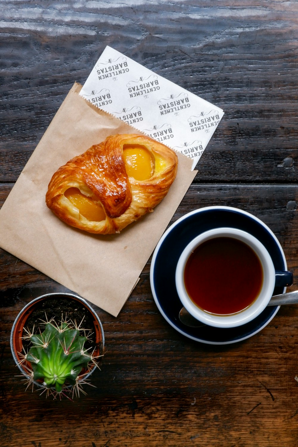 a cup of coffee and a bag of food on a table