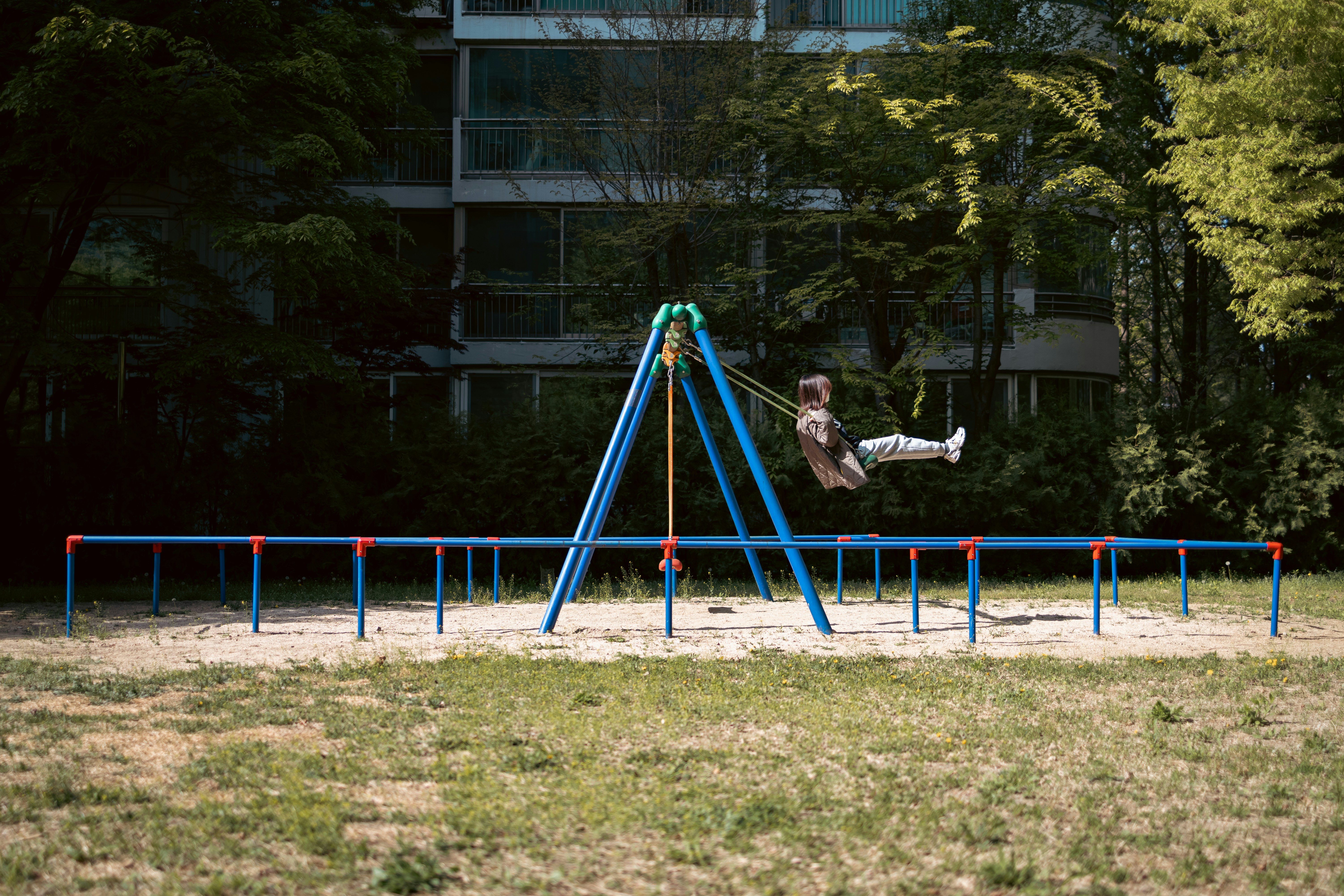 a couple of people jumping over a trampoline