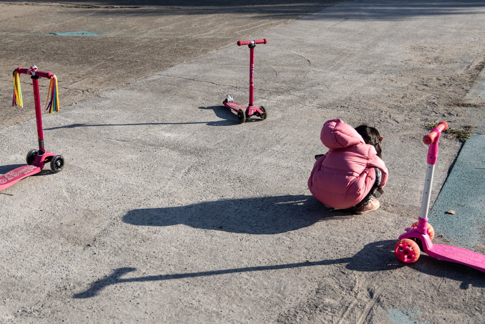Una niña jugando con un oso de peluche rosa