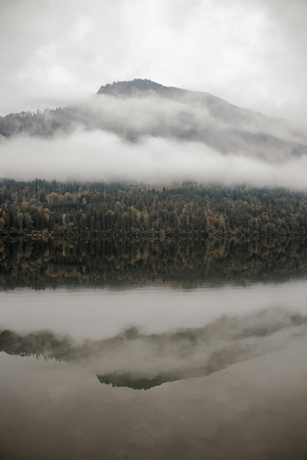 a lake with trees and mountains in the background