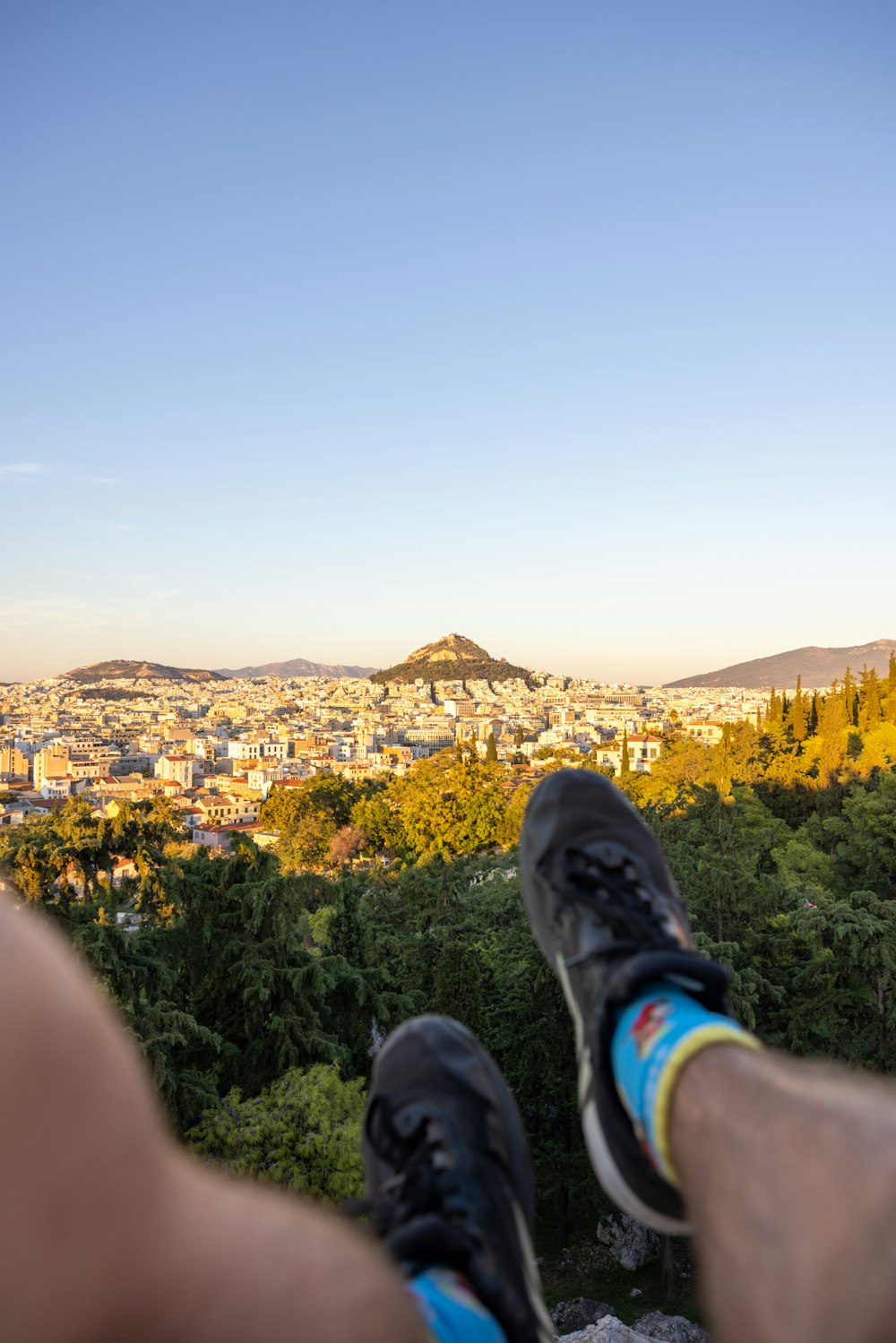 a person's feet on a ledge overlooking a city