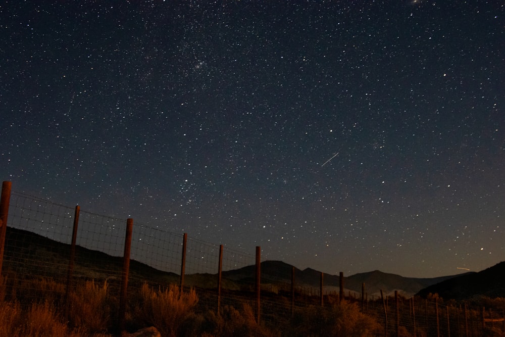 a fence with a starry sky above it