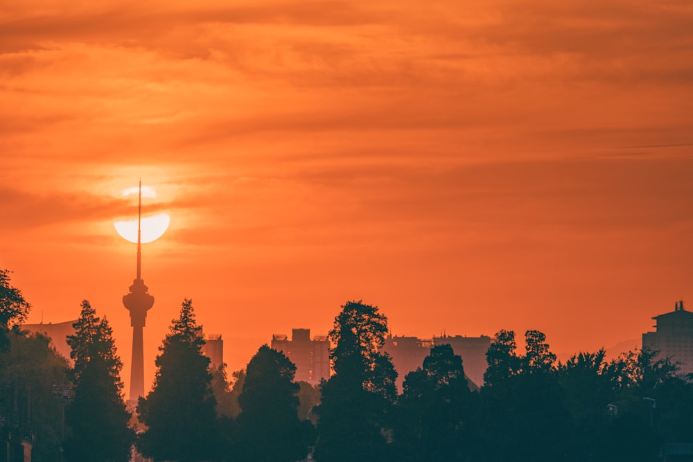 a tall tower with a sunset in the background