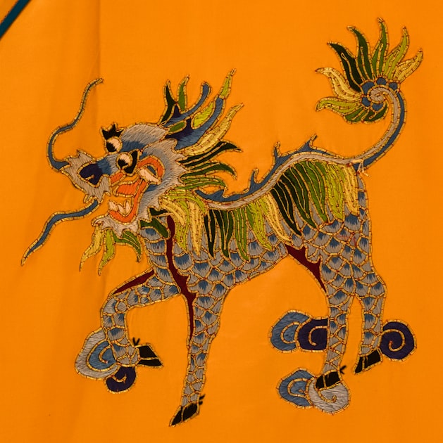 Close-up of a person in traditional Chinese textile attire — the kind of surface work and horizontal silhouette that connects Tang Dynasty pouchwork to the modern bread bag format.