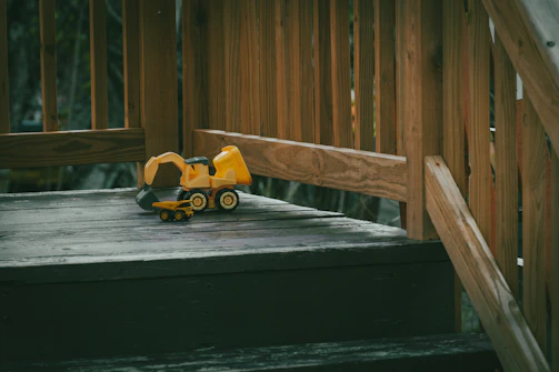 a toy truck on a wooden bridge
