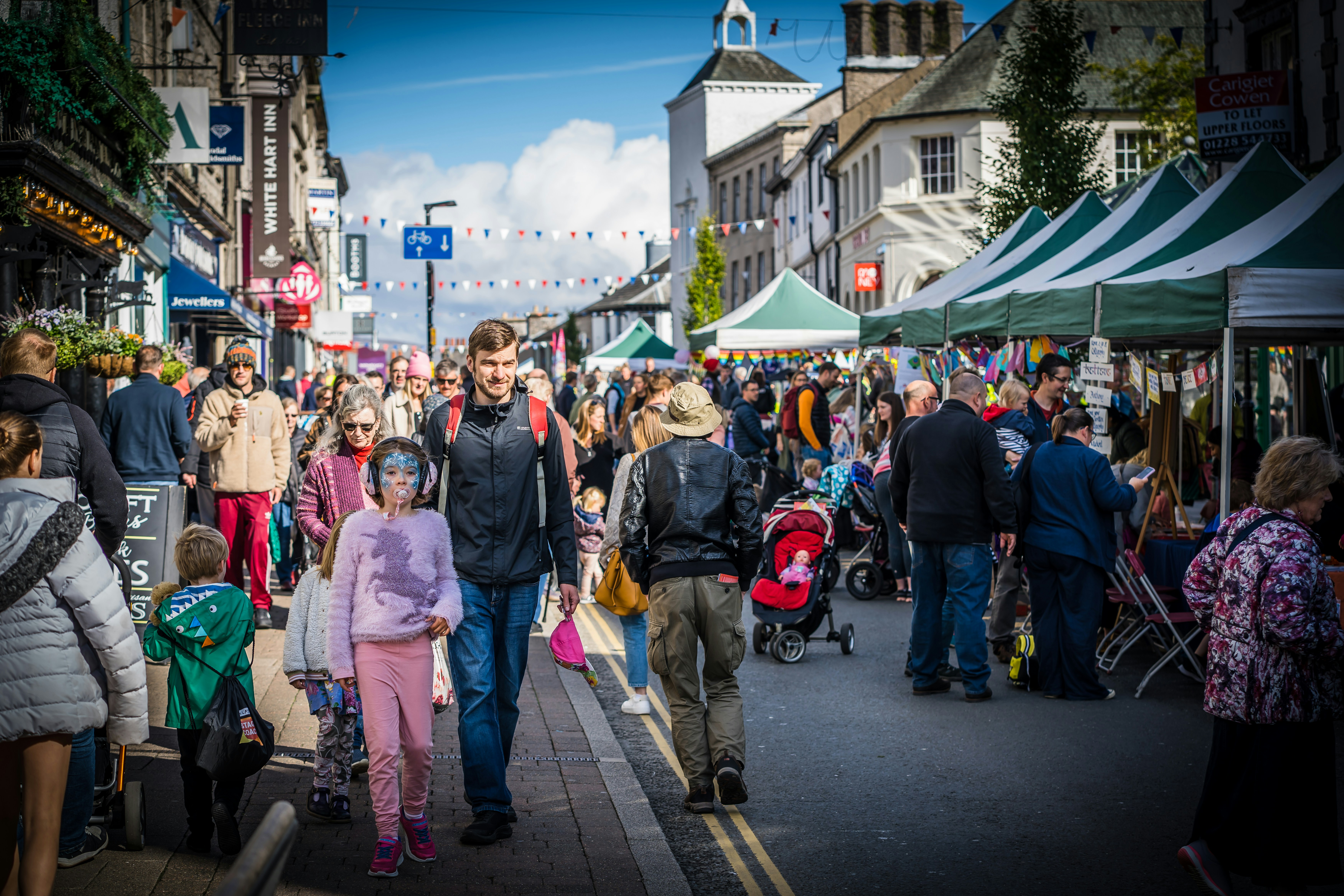 a crowd of people walking down a street