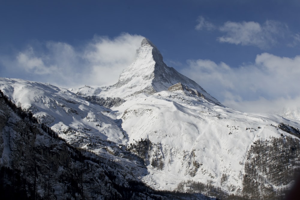 a snowy mountain with clouds