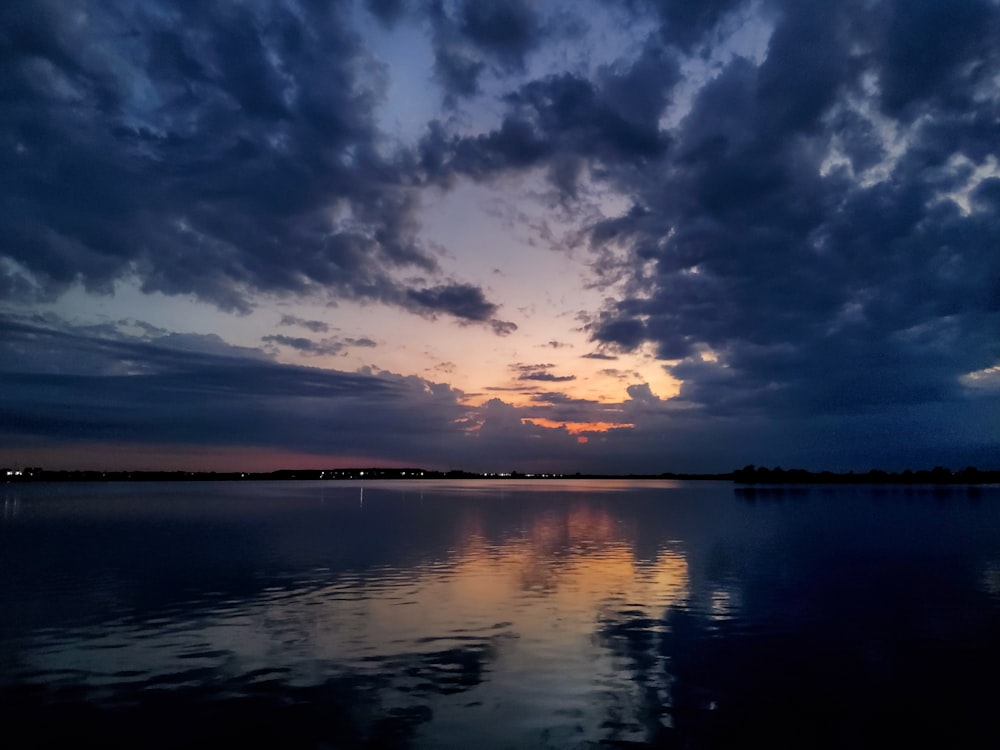 a body of water with clouds above it