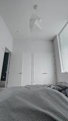 Spacious bedroom with minimalist design and soft linens.