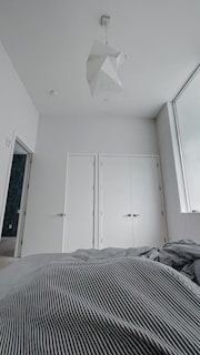 Luxurious bedroom with large windows, blue and white color scheme, and minimalist furniture