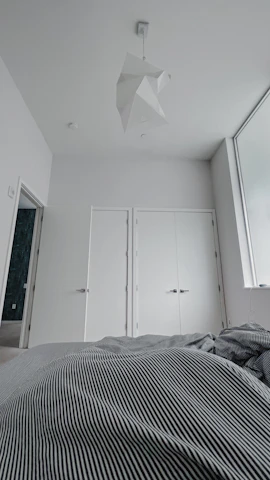 Comfortable bedroom with minimalist design, black and white tones, and a splash of red.