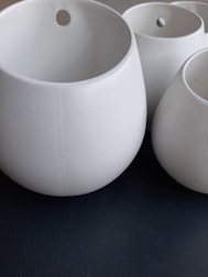 Colorful ceramic pots arranged neatly with small plants inside.