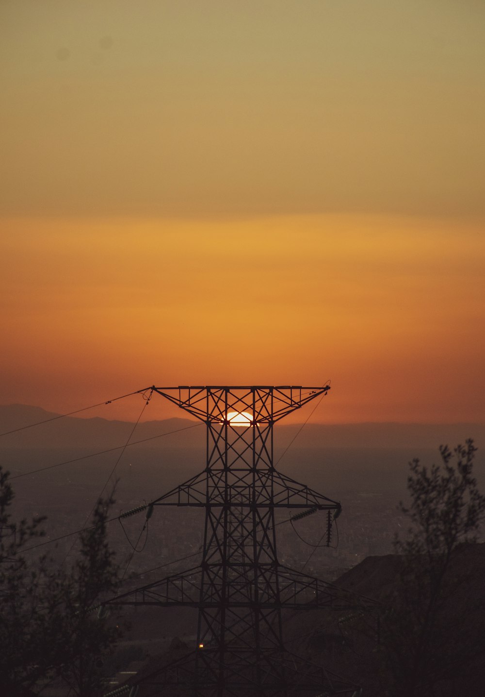 a large metal structure with a sunset in the background