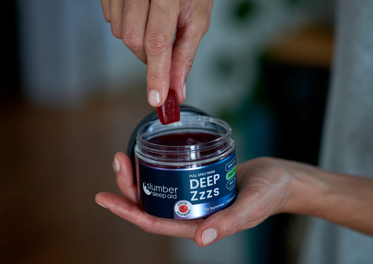 Hand taking a single gummy from a sealed edible jar, showing proper closed-container storage