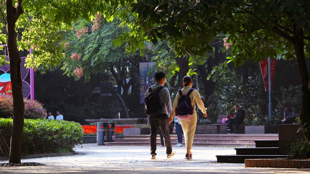 a couple of people walking on a sidewalk