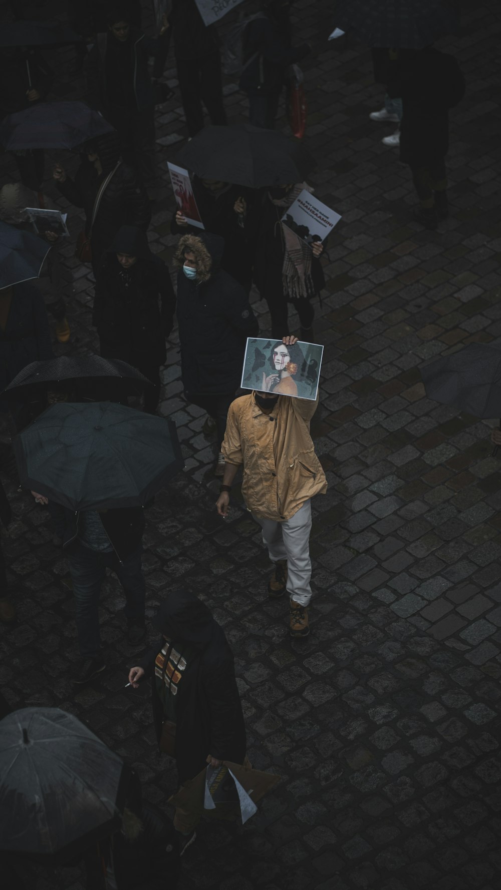 Eine Gruppe von Menschen, die mit Regenschirmen eine Straße entlang gehen