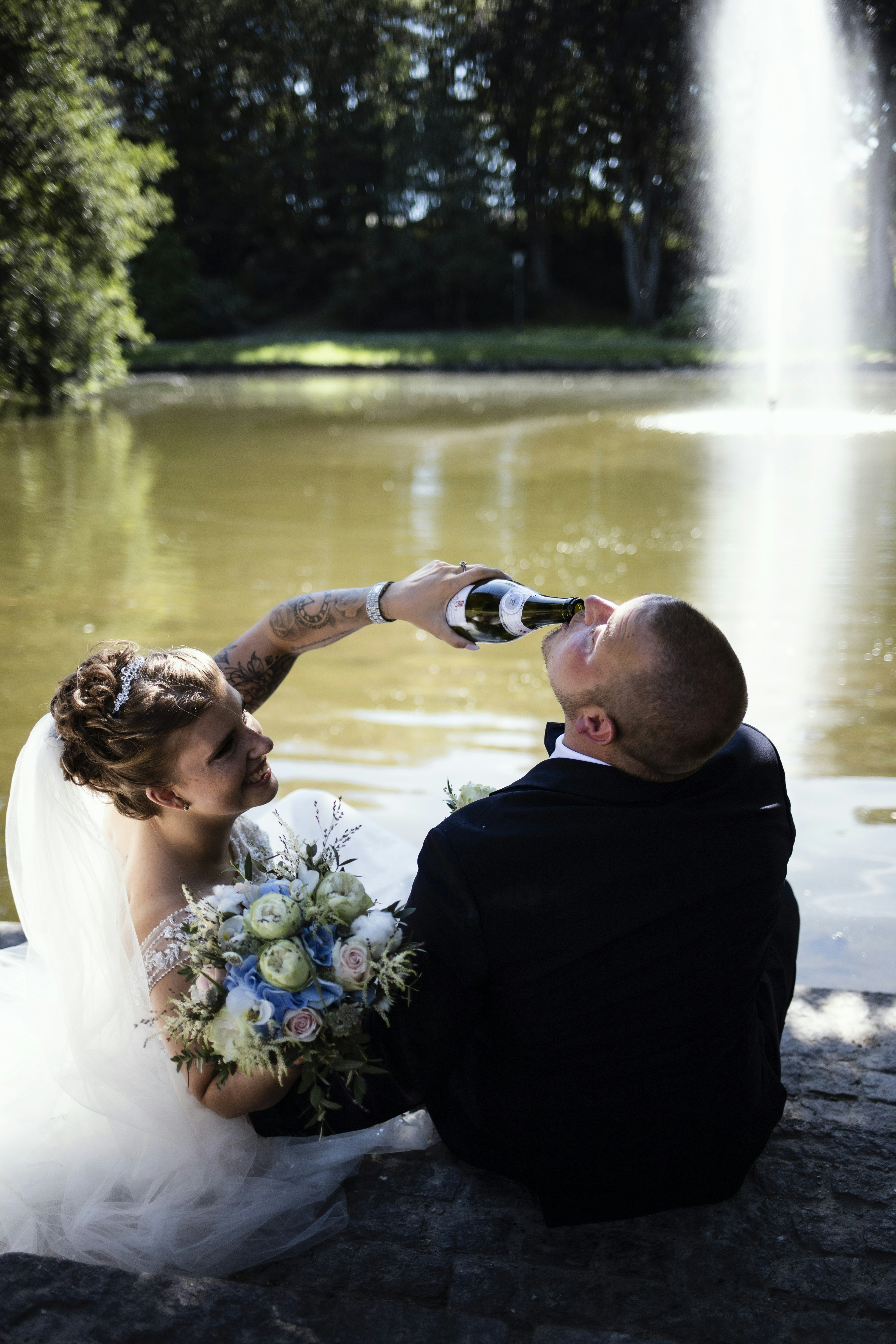 a person pouring a bottle of champagne into a person's mouth