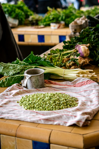 Bundles of fresh green beans and sweet potatoes laid out on a traditional woven mat