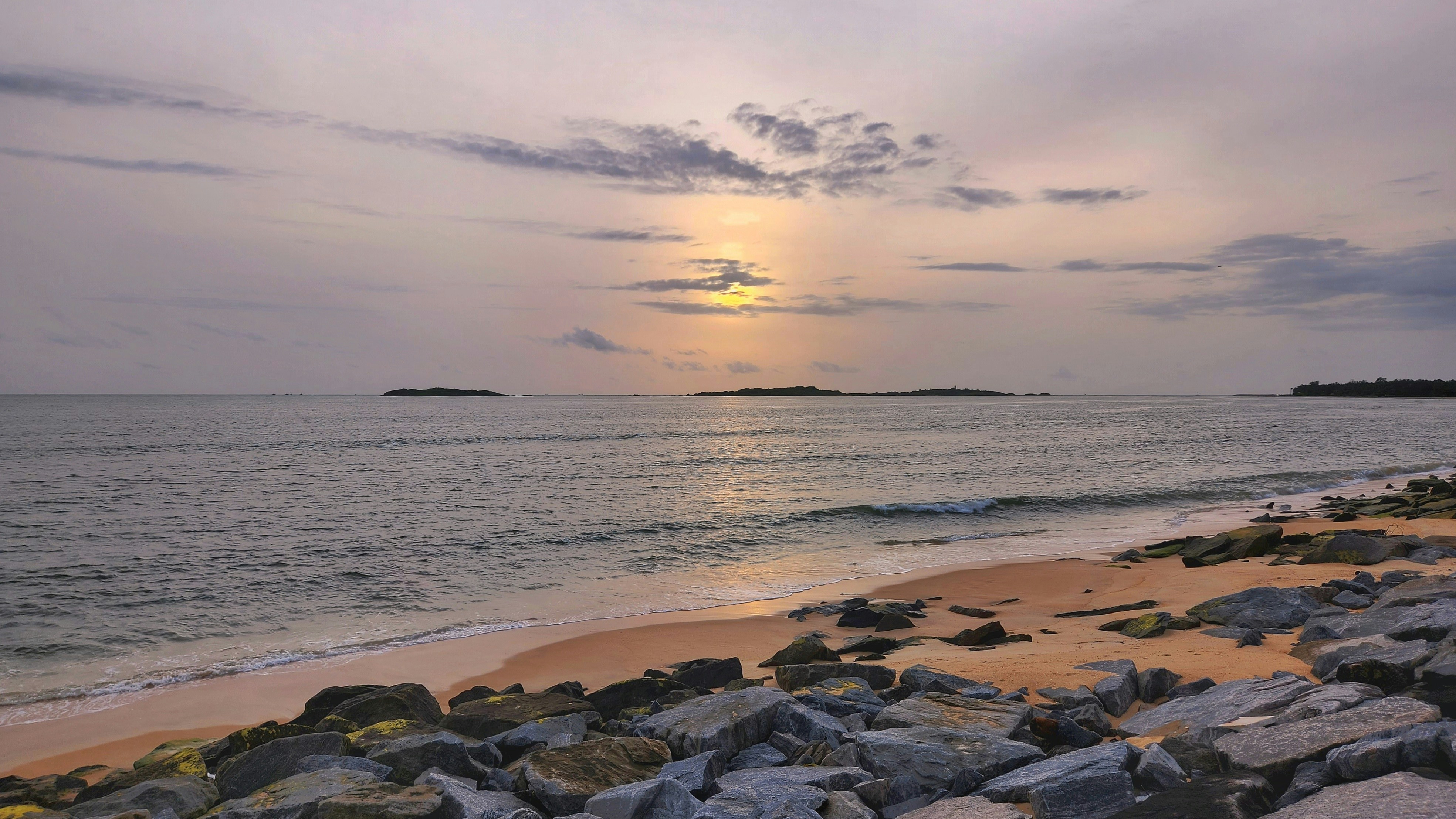 pantai berbatu dengan badan air di latar belakang