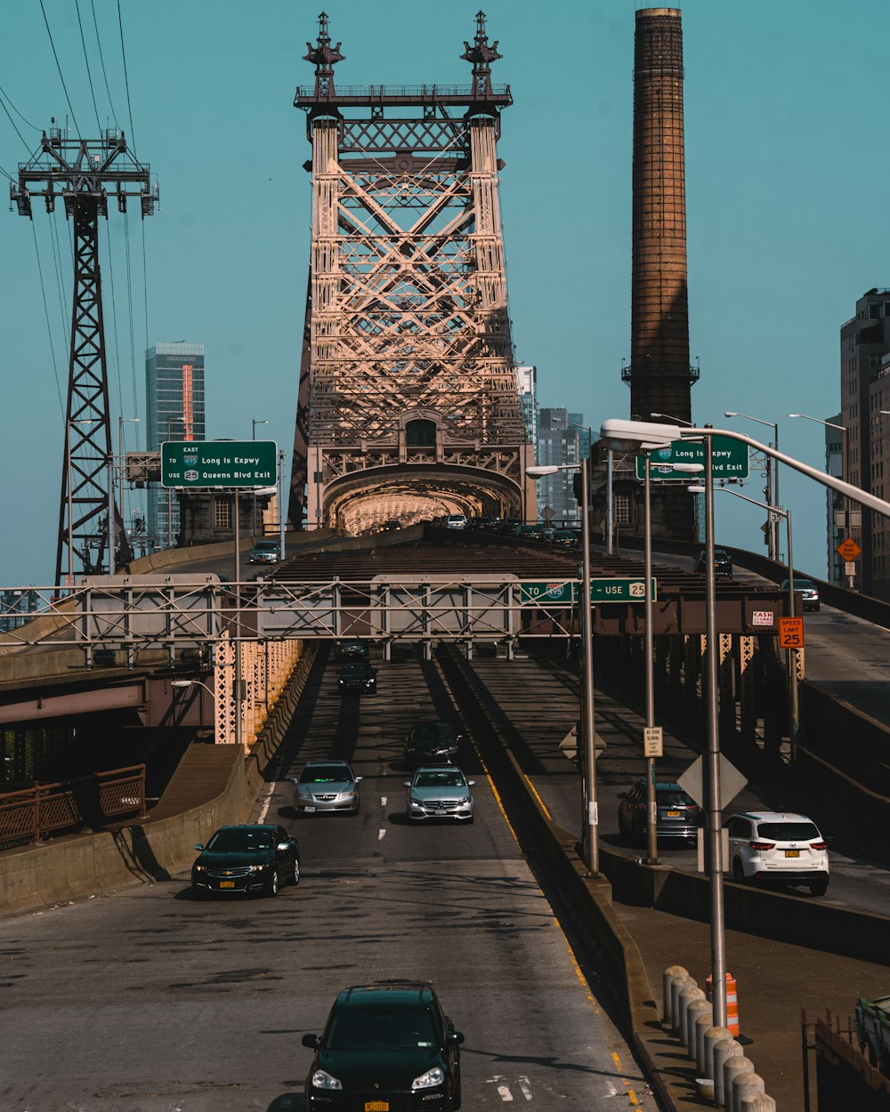 a bridge with cars on it and a tall tower in the background