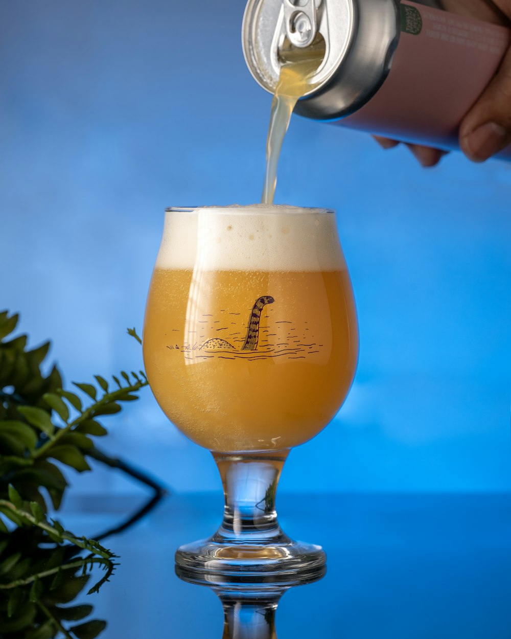 a hand pouring a glass of beer