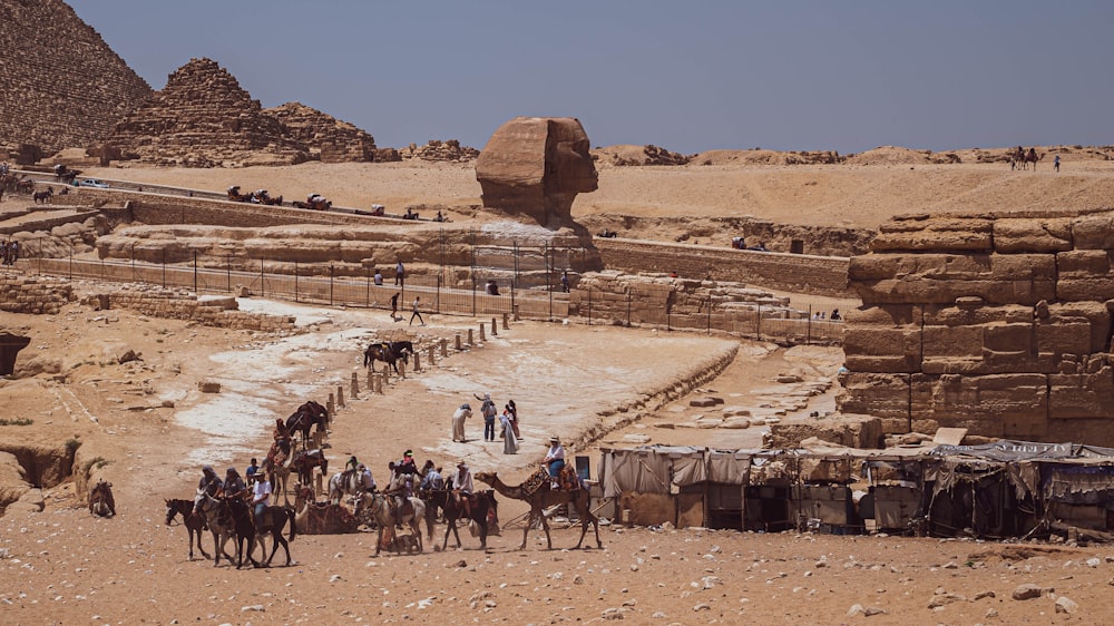 a group of people riding camels in a desert