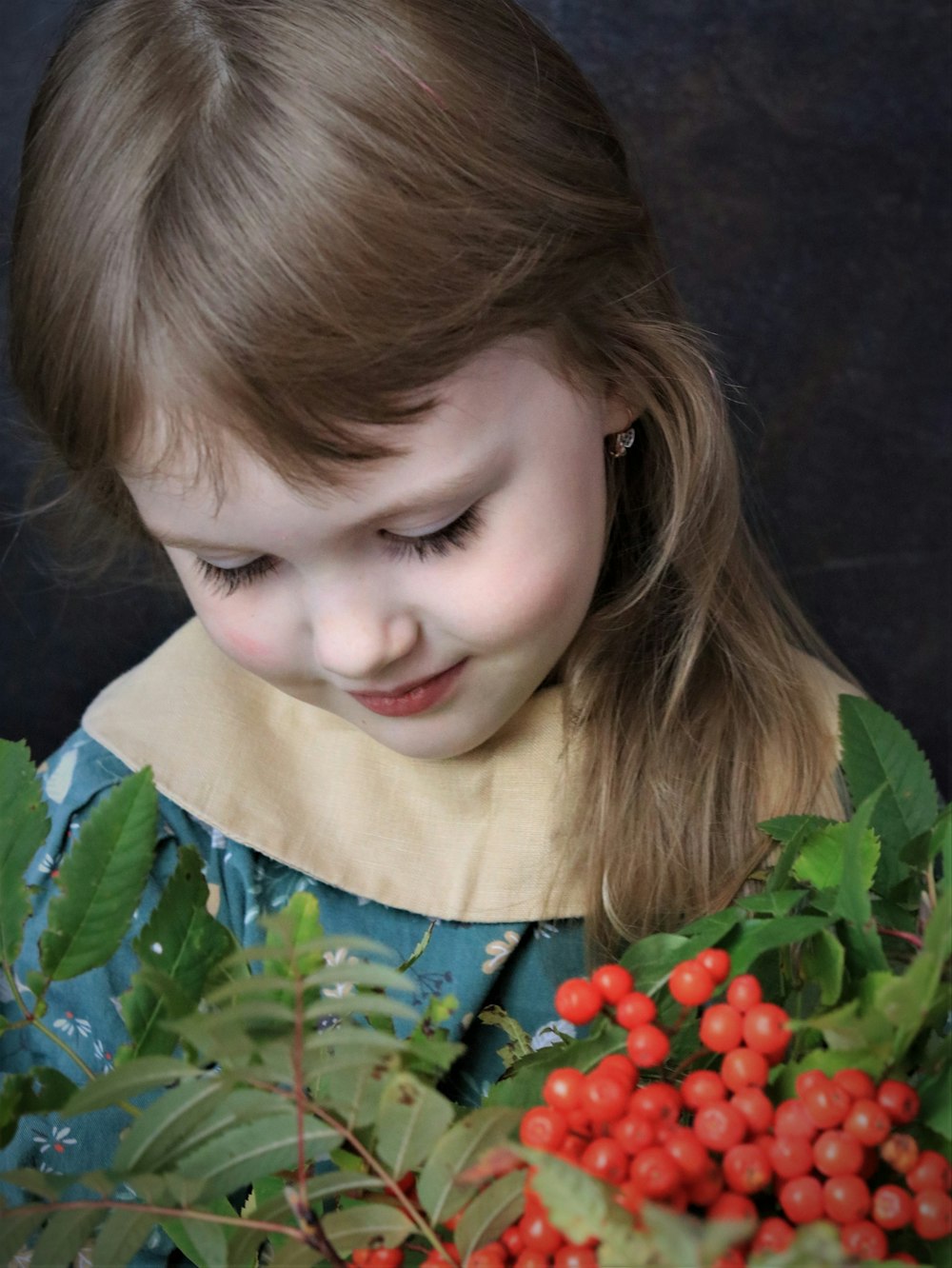 a young girl looking at a bush