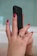 Close-up of a happy woman holding her phone displaying the ringsizar app measuring her finger.