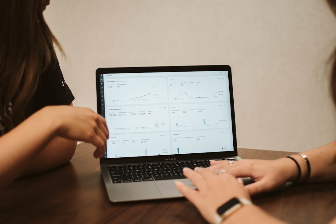 a woman using a laptop, Two coworkers collaborate on a work project with the help of GRIN’s suite of data-reporting tool