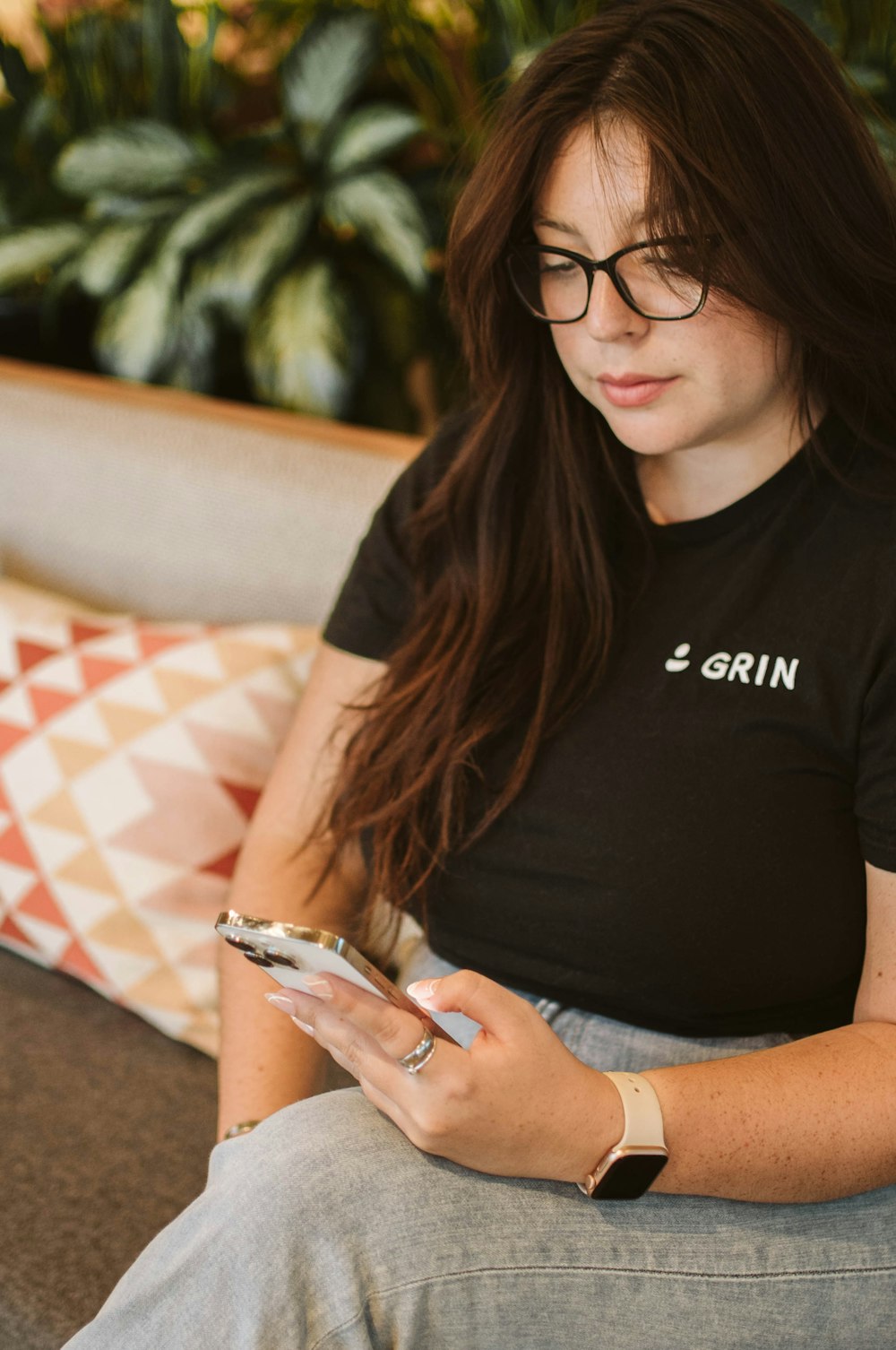 a woman sitting on a couch looking at her phone