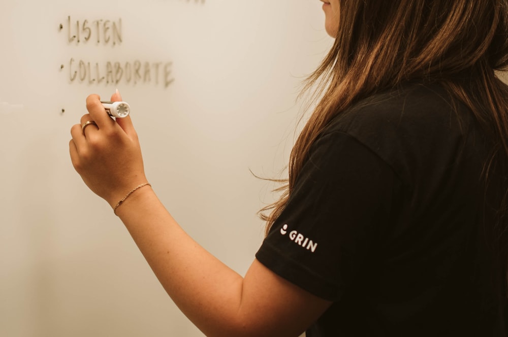 a woman writing on a whiteboard