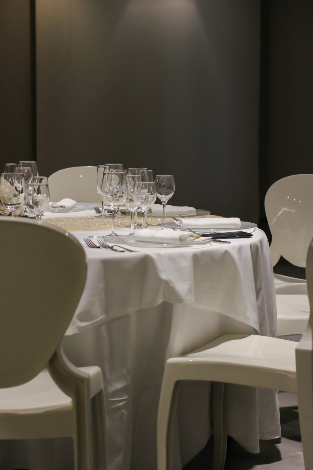 a table with white chairs and white tables with white plates and glasses