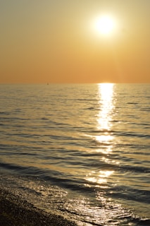 Sunset view from the yacht’s deck with warm golden light reflecting on the calm sea.