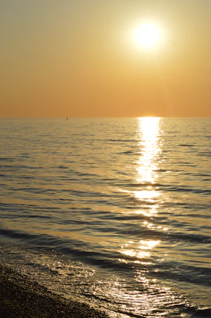 Sunset view from the catamaran with golden light reflecting on the calm Caribbean sea.