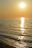 Sunset view over the guest house terrace with soft golden light reflecting on the sea.