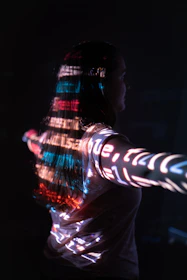 A person standing still while a 3D scanner captures their detailed figure at a lively festival.
