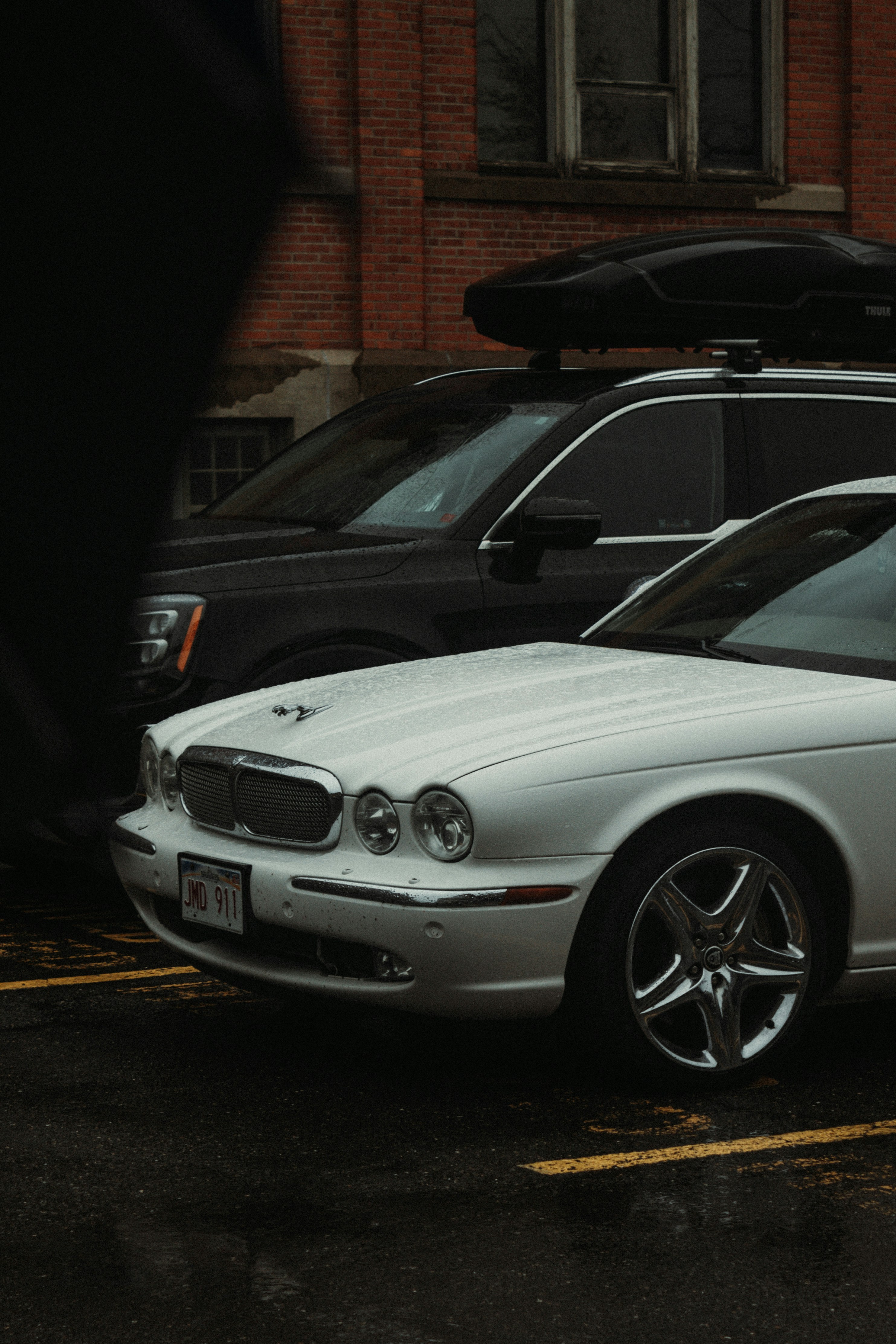 a silver car parked next to a black car