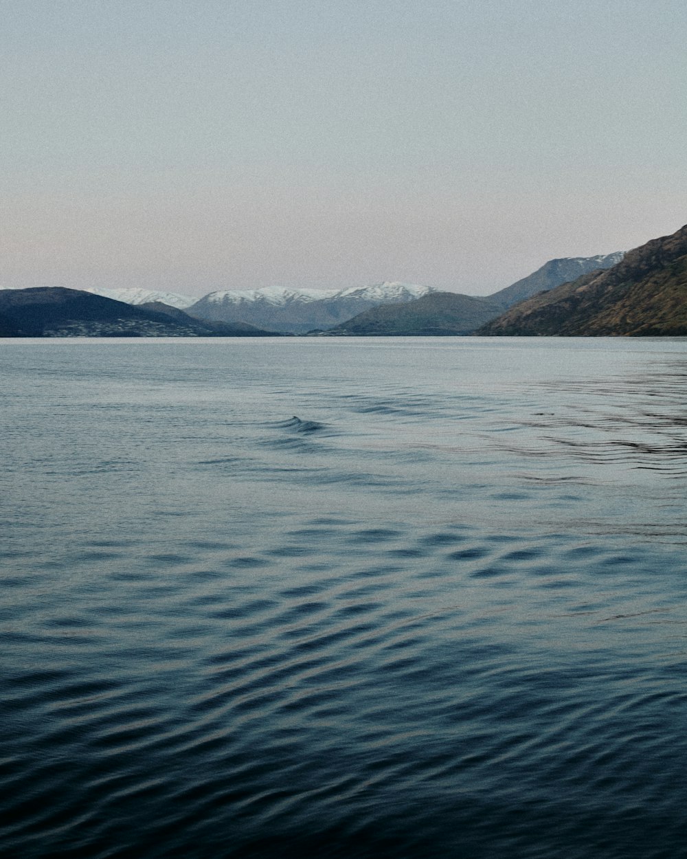 a body of water with mountains in the background