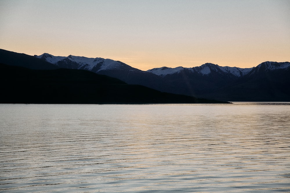 a body of water with mountains in the background