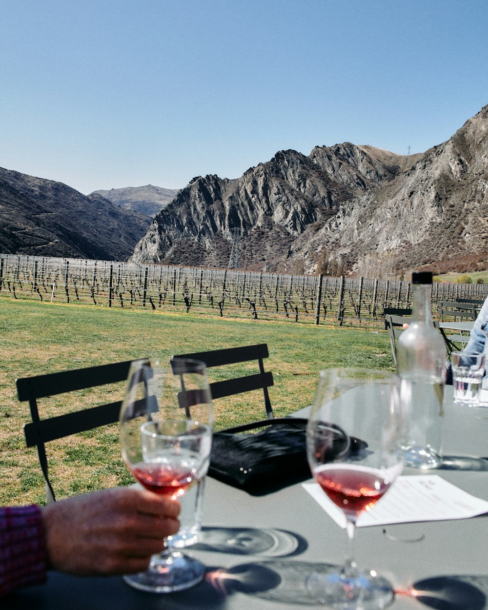 a couple of wine glasses on a table in front of a mountain