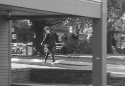 A blurred figure in a suit walking through a busy urban street, symbolizing covert operations.