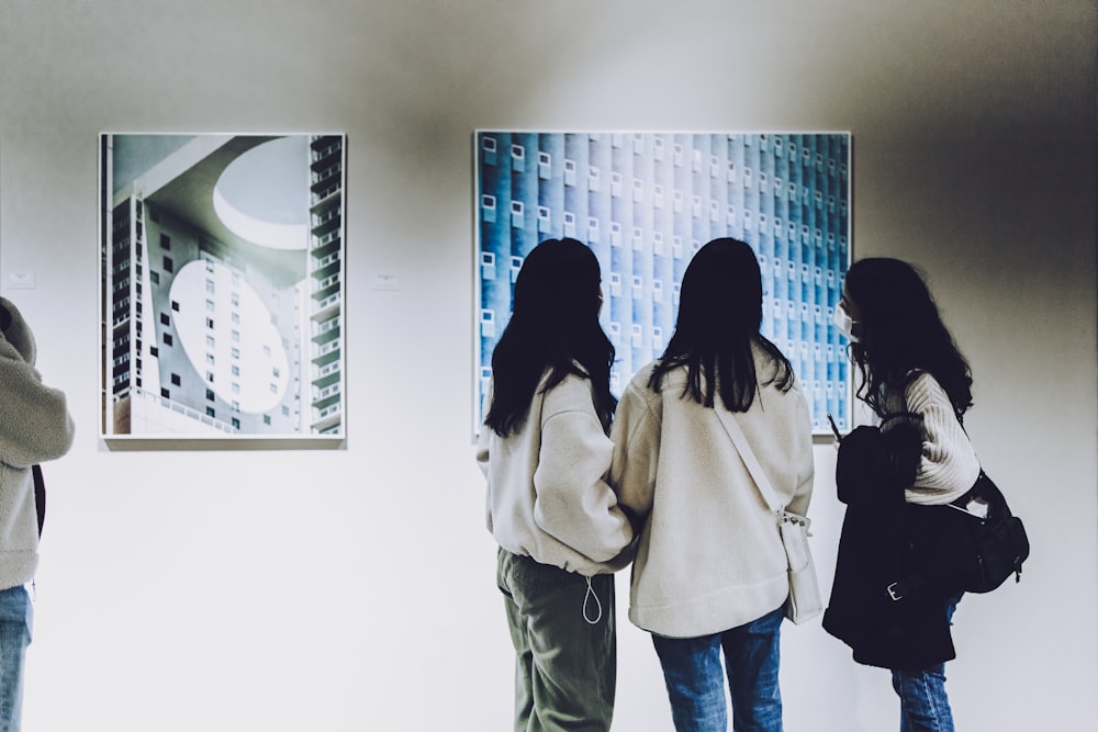 a group of people looking at a picture on a wall