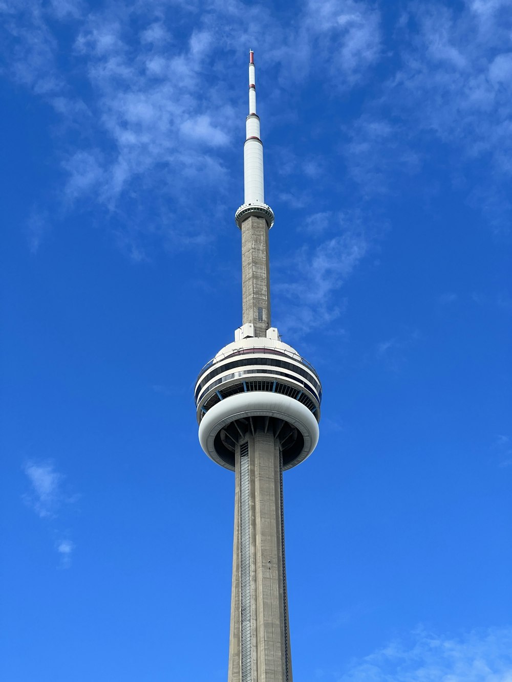 una torre alta con una parte superior puntiaguda con la Torre CN en el fondo