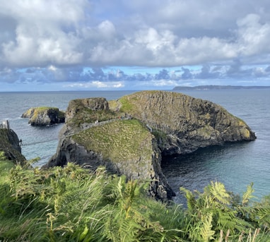 a rocky cliff with a body of water below