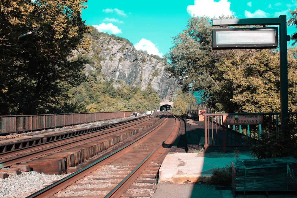 train tracks with trees and mountains in the background