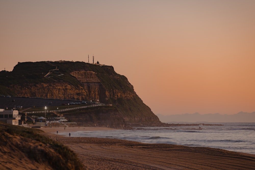 a beach with a hill and buildings