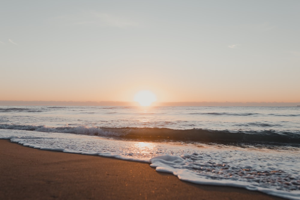 波と太陽を背景にしたビーチ