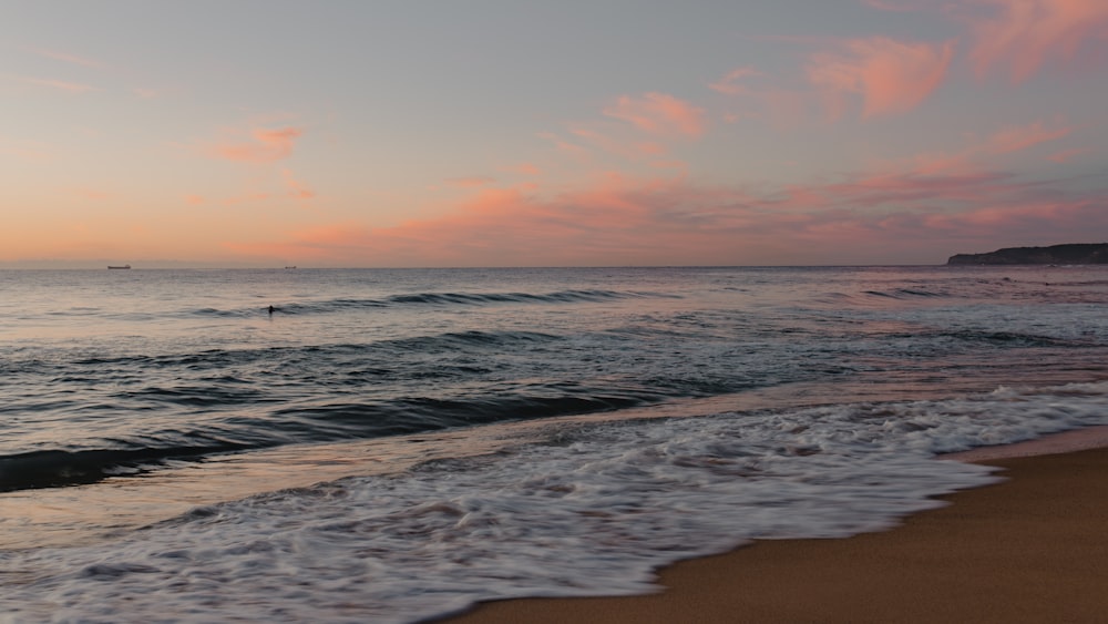 波と夕日のビーチ
