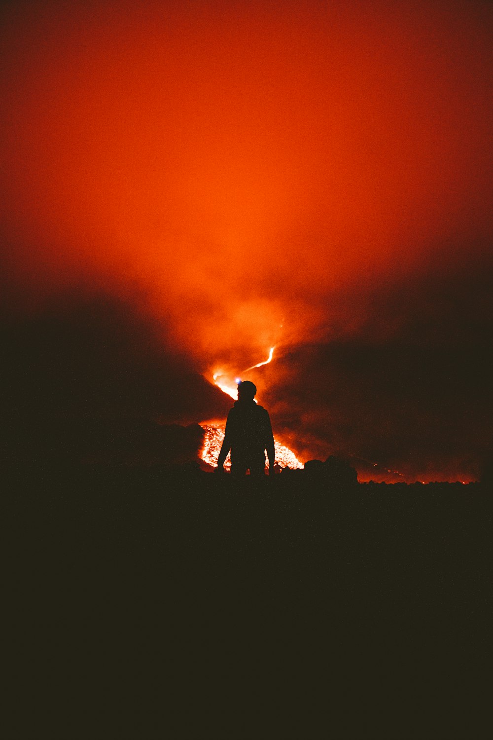 Una persona parada frente a un gran fuego