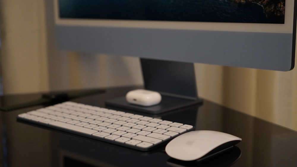 a computer keyboard and mouse on a desk